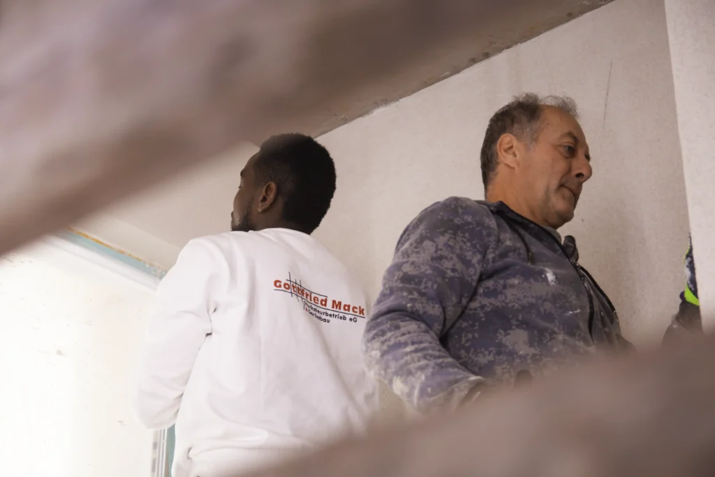 Zwei Stuckateure des Gottfried Mack Stuckateurbetrieb Reutlingen/Pliezhausen beim Verputzen einer Innenwand